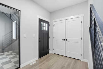 Hallway with a black door and white doors