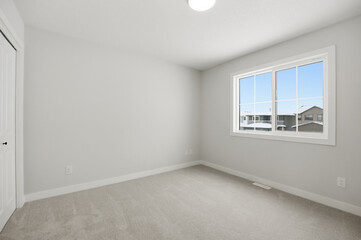 Very clean and empty bedroom with a large window