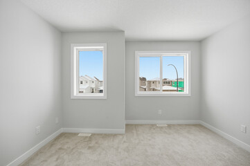 White room with two windows and a white wall