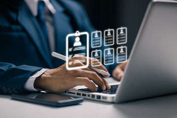 A recruiter reviews multiple digital resumes on a laptop, representing candidate databases, talent screening, recruitment technology, employee evaluation, and modern hiring systems.