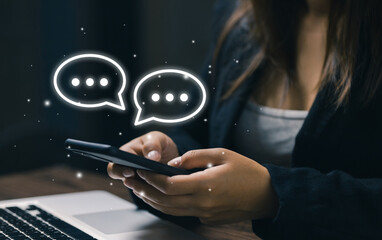 A user types on a smartphone with digital chat bubbles, representing online communication, instant messaging, customer interaction, social connection, and modern mobile communication technology.
