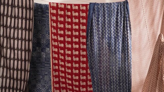 Tracking shot of Indian colorful block printed sarees in 4K, showing vibrant fabric patterns, traditional craftsmanship, rich texture, and cultural fashion visuals.