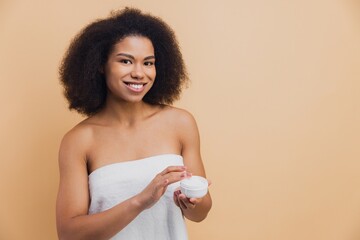 African American woman smiling doing skincare routine
