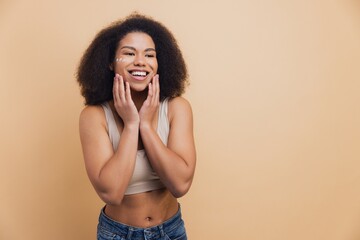 African American woman smiling doing skincare routine