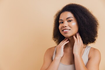 African American woman applying face cream for skincare