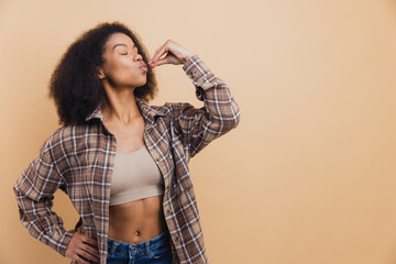 African American woman enjoying good taste kissing fingertips