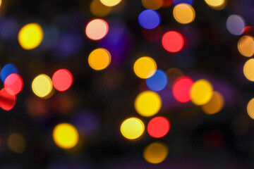 Fototapeta premium An abstract image of colorful Bokeh lights creating a soft, blurred yet vivid background of yellow, red, and blue light circles. This shimmering backdrop perfectly conveys the magical atmosphere of a 