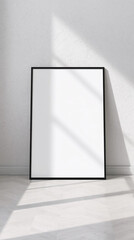 Minimalist Black Frame Leaning Against White Textured Wall in Bright Sunlit Room.