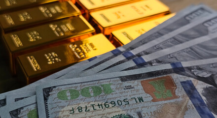 Gold bars and cash currency displayed together on a flat surface