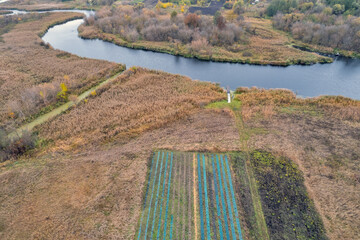 Aerial view of farmland with crops near river, Ukraine.