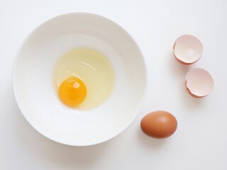 Raw egg in a white background. Minimalist food and cooking concept with copy space.