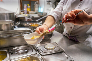 The chef at the kitchen prepare the food for the guest by moving and handling several devices to get it complete