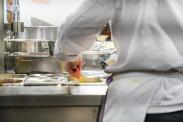 The chef at the kitchen prepare the food for the guest by moving and handling several devices to get it complete