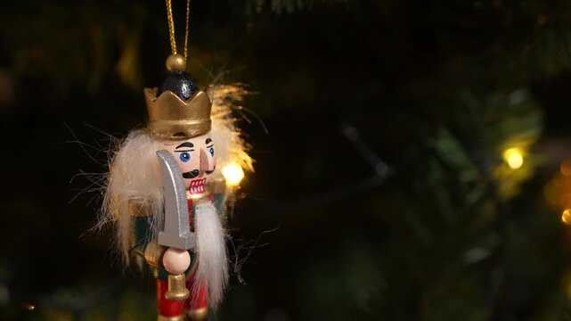 A nutcracker soldier ornament with a Christmas tree visible in the background, symbolising holiday tradition and festive Christmas spirit. 4 k video