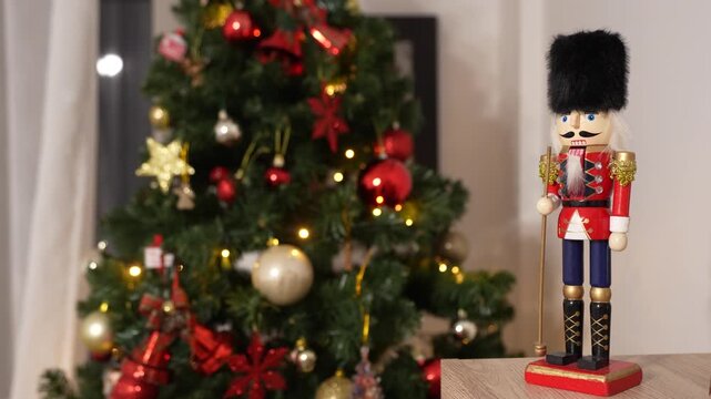 A nutcracker soldier ornament with a Christmas tree visible in the background, symbolising holiday tradition and festive Christmas spirit. 4 k video