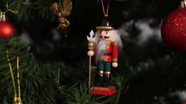 A nutcracker soldier ornament with a Christmas tree visible in the background, symbolising holiday tradition and festive Christmas spirit. 4 k video