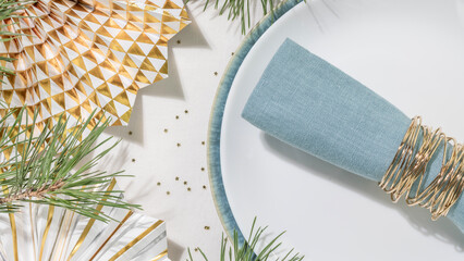 Christmas Holiday Table Setting With Blue Linen Napkin, White Plate And Golden Festive Accents. Perfect For Christmas and New Year Dinner Invitations, Winter Seasonal Decor And Celebration Branding