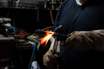 Blacksmith forging a Celtic knife in a traditional forge. Craftsman heating steel with open flame, handmade blade creation, ancient metalworking technique, fire and manual labor in workshop