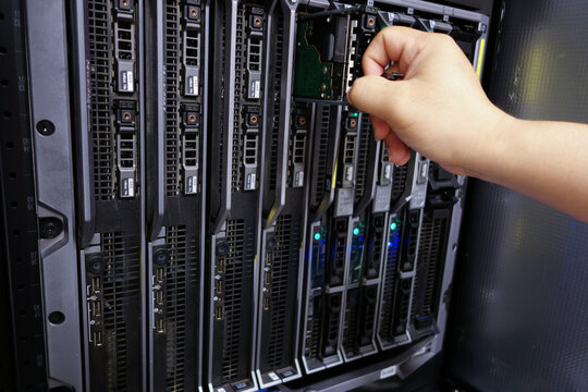 Hand Inserting Hardware Into Server Rack - Powered by Adobe