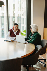 Business mentoring session at modern office meeting table.