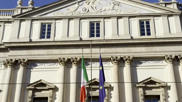 La Scala theater facade with Italian flag and EU flag Milan Italy