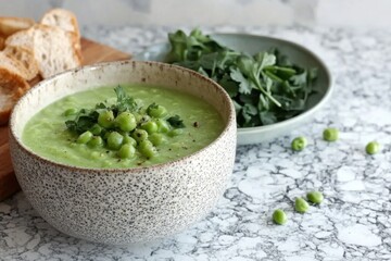 Minimalistic green healthy soup with fresh peas and herbs