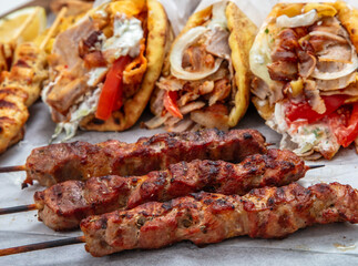Gyro sliced meat pita bread wraps, pork souvlaki skewers, traditional street food, closeup