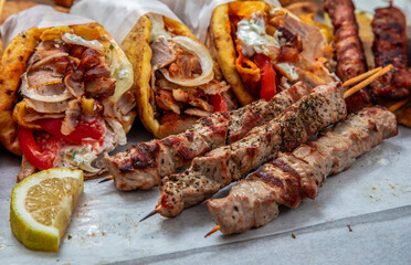 Gyro sliced meat pita bread wraps, pork souvlaki skewers, traditional street food, closeup
