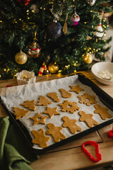 Holiday background. Uncooked raw Christmas gingerbread cookies on baking tray, lifestyle