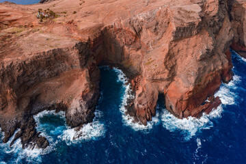 Aerial view shows rugged volcanic cliffs and sea caves at Ponta de Sao Lourenco, Madeira, Portugal....
