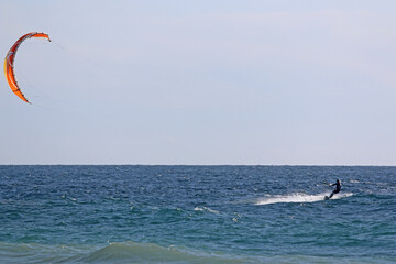 kitesurfer riding his board on the sea	