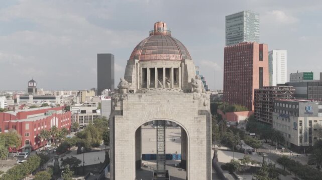 Aerial view of the Monument to the Revolution at Plaza de la Rep&uacute;blica. The Drone hovering steadily and revealing the surrounding urban fabric and the distant Historic Center of CDMX, Shot in D-Log