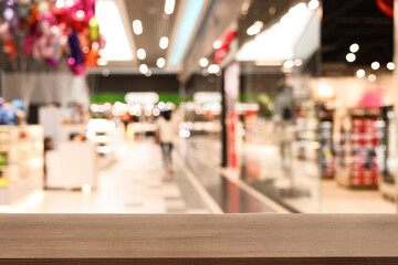Empty wooden table against blurred view of shopping mall. Space for design