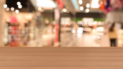 Empty wooden table against blurred view of shopping mall. Space for design
