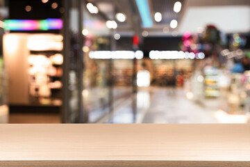 Empty wooden table against blurred view of shopping mall. Space for design