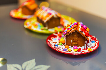 Close up view of colorful Christmas gingerbread house decorated with candies on festive plate. Sweden.