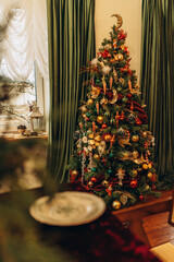 Beautifully decorated Christmas tree with golden ornaments and red accents in cozy interior
