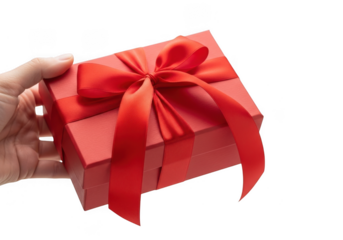Hand holding a small red gift box with a ribbon tied around it isolated on transparent background