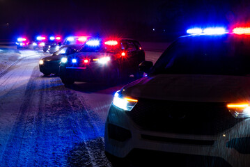 Police patrol vehicle at nighttime winter checkstop with flashing emergency lights © Ryan