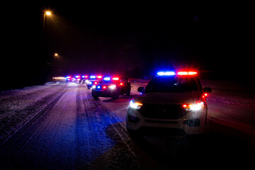 Police patrol vehicle at nighttime winter checkstop with flashing emergency lights © Ryan