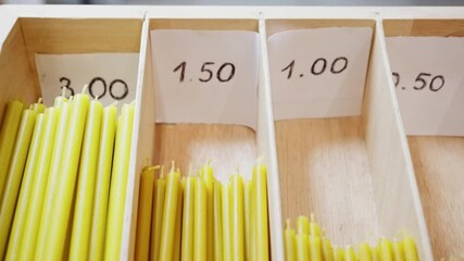 Wooden Shelf With Price Tags, Shelf Showcasing Colored Candles With Handwritten Prices For Shoppers, Display Of Various Taper Candles In Compartments With Handwritten Price Tags For Customers