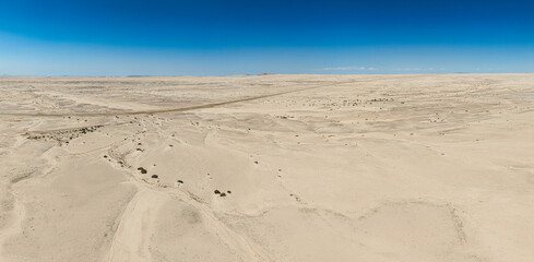 This high-quality drone photograph presents a sweeping aerial round flight over the dramatic landscapes of Namibia, offering a breathtaking bird’s-eye view of one of the world’s oldest deserts. The ca