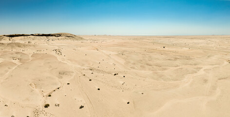 This high-quality drone photograph presents a sweeping aerial round flight over the dramatic landscapes of Namibia, offering a breathtaking bird’s-eye view of one of the world’s oldest deserts. The ca