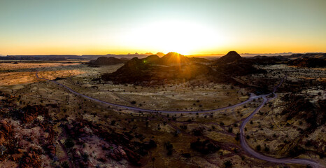 This high-quality drone photograph presents a sweeping aerial round flight over the dramatic landscapes of Namibia, offering a breathtaking bird’s-eye view of one of the world’s oldest deserts. The ca