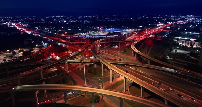 Beautiful night cityscape with stunning illumination. Drone flight around lively intersection with fast moving cars.