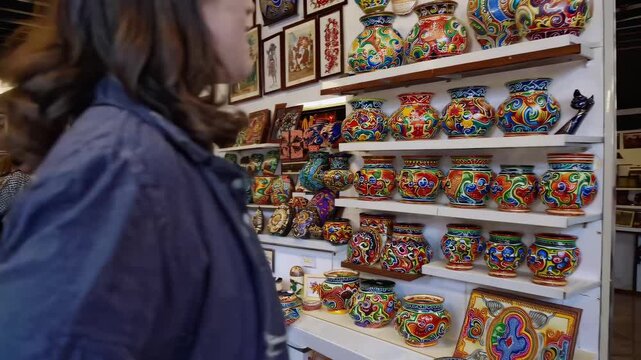 In this engaging video, a woman explores a vibrant collection of handcrafted pottery and colorful art pieces. Each unique item showcases exquisite craftsmanship, inviting viewers to appreciate the bea