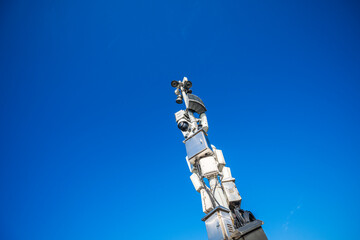 Obraz premium Towering Surveillance: A Look at Modern Security Systems Against a Bright Blue Sky