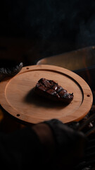 Grilled Steak on Wooden Board with Dark Moody Lighting