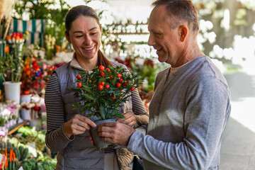 middle-aged man and woman happily choosing flowers at a flower market