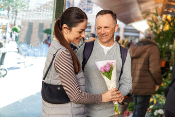 middle-aged man and woman happily choosing flowers at a flower market